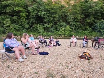 Women sit on a gravel beach