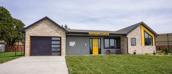 A house sits on the property of a high school