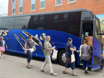 People walking onto a large, blue bus.