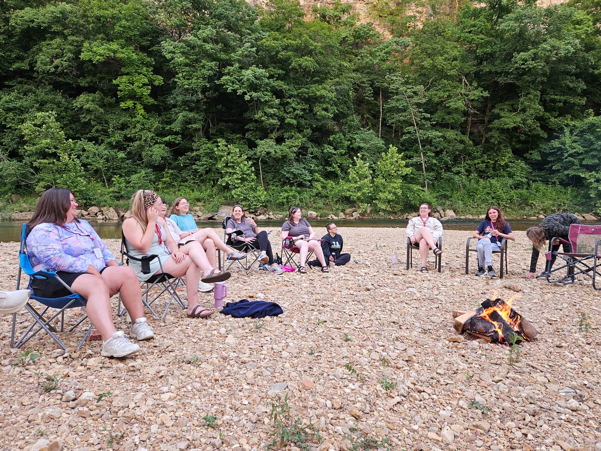 Women sit on a gravel beach