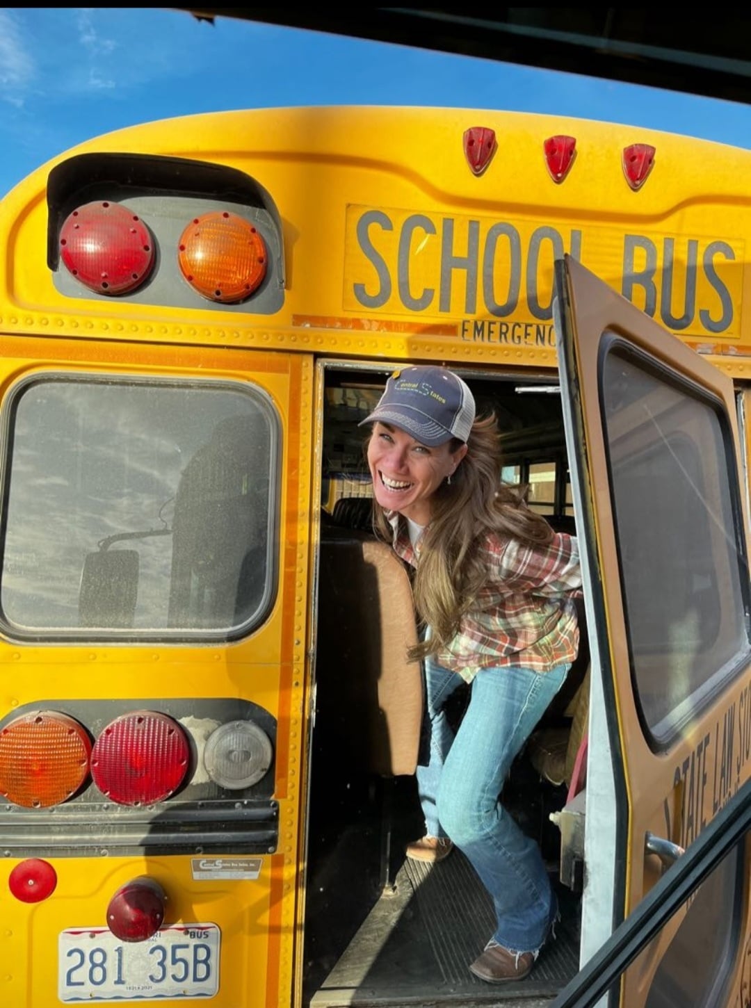 A woman stands inside a yellow school bus