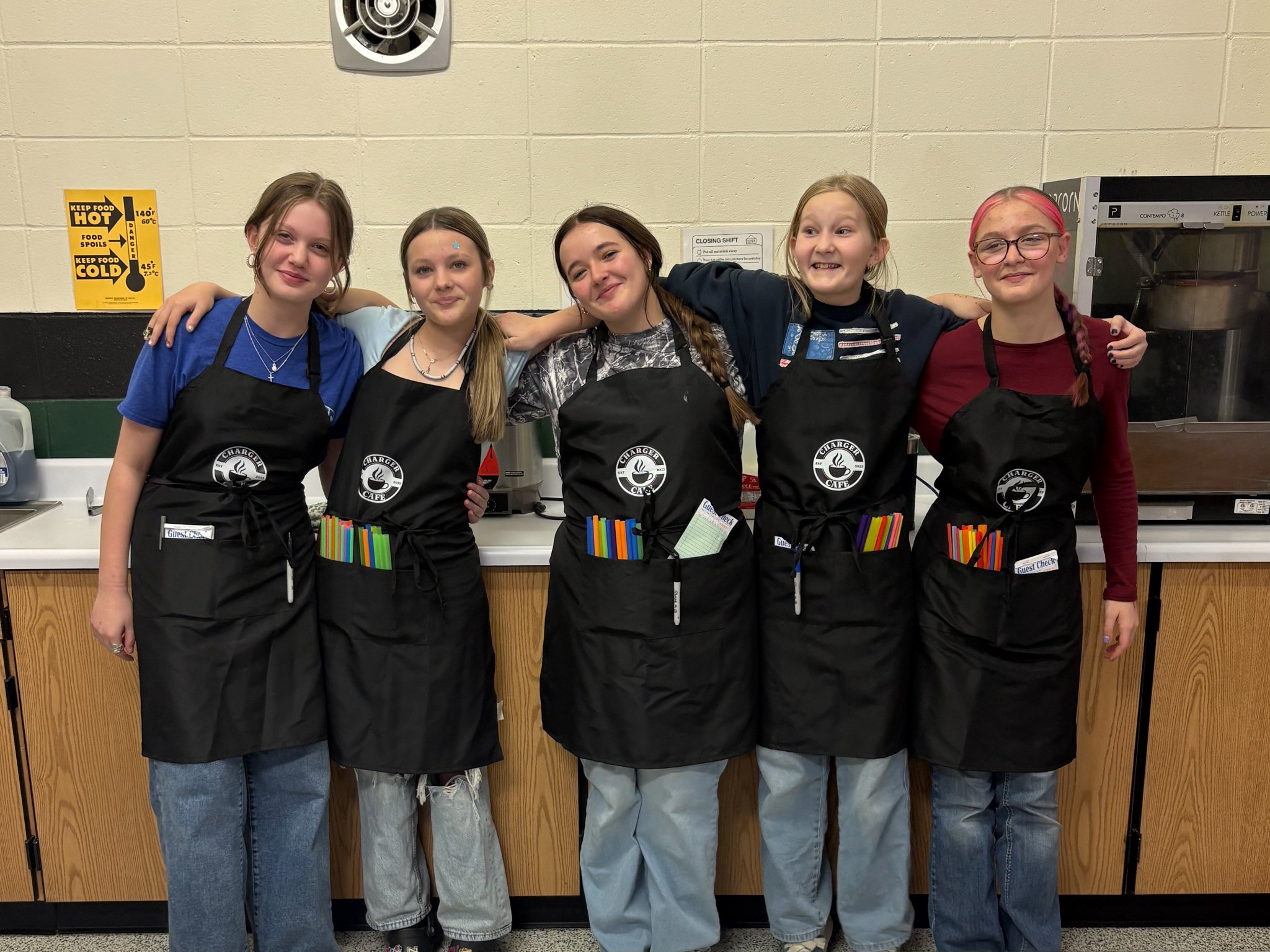 Five middle school girls wearing aprons