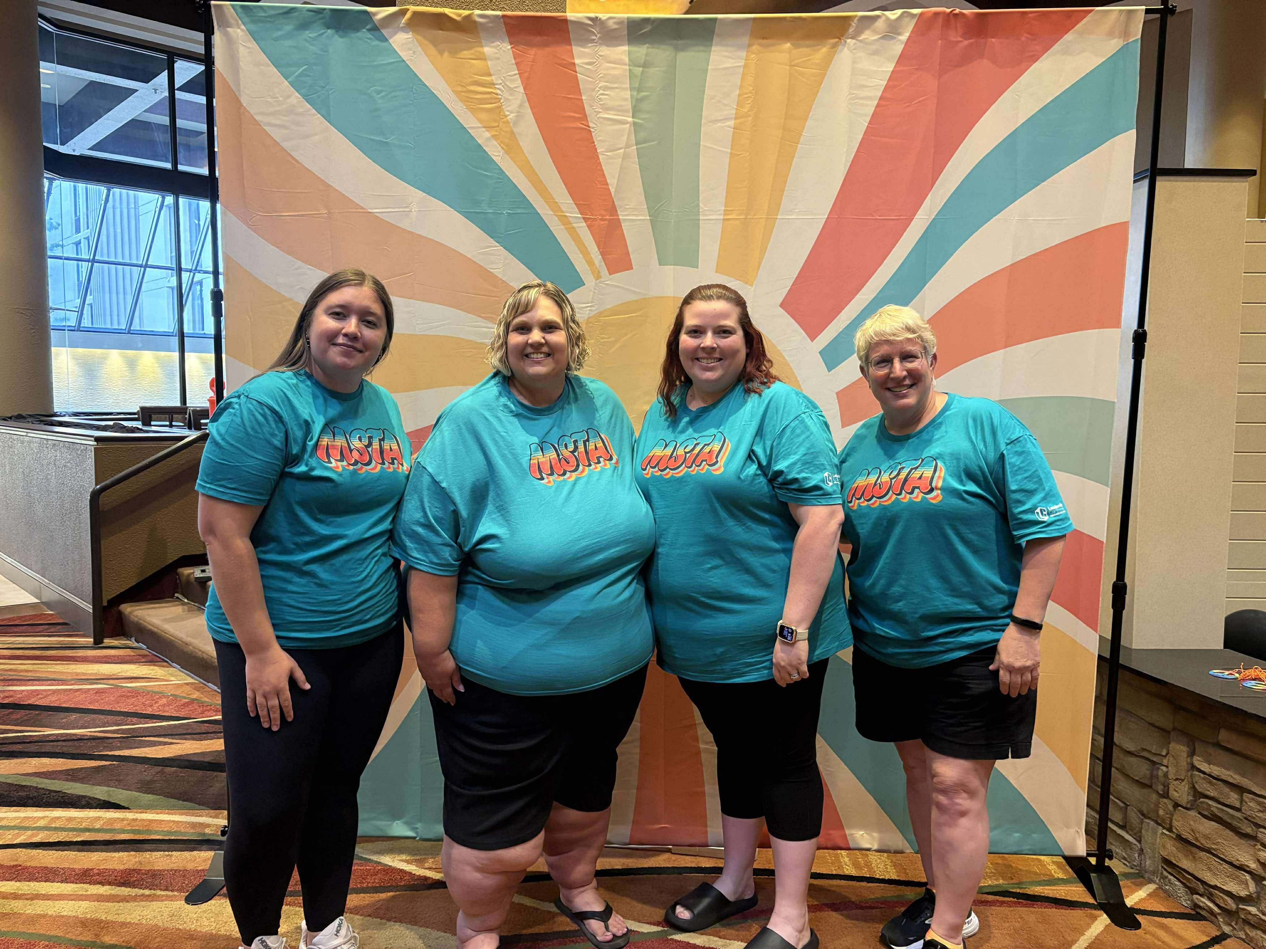 Four women in blue "MSTA" shirts